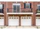 Townhome garages with white doors and classic brick exterior; great curb appeal at 1057 3Rd Nw Ave, Carmel, IN 46032