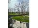 View of the expansive backyard with a fire pit area and mature trees from the upper patio at 1066 N Dogwood Way, Greenfield, IN 46140