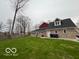 A manicured backyard lawn and a view of the back of this brick and vinyl home at 1066 N Dogwood Way, Greenfield, IN 46140