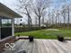 Backyard wooden deck with a view of large lawn and trees create a peaceful outdoor space at 1066 N Dogwood Way, Greenfield, IN 46140