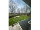 Aerial view of grassy backyard and deck overlooks a fire pit area with shed and tall trees at 1066 N Dogwood Way, Greenfield, IN 46140