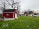 View of the spacious red barn with white trim in the back yard at 1066 N Dogwood Way, Greenfield, IN 46140
