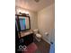 Powder room features wood look flooring, granite counters, vanity and toilet at 1066 N Dogwood Way, Greenfield, IN 46140