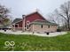 Exterior view of the home featuring brick and vinyl siding, black gutters, and a well-manicured lawn at 1066 N Dogwood Way, Greenfield, IN 46140