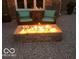 Inviting backyard patio featuring a stone firepit radiating warmth and ambiance for outdoor gatherings at 1066 N Dogwood Way, Greenfield, IN 46140