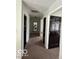 Hallway with neutral walls, carpeted floor, and doors leading to various rooms at 1066 N Dogwood Way, Greenfield, IN 46140