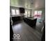 Bright kitchen features an island with a cooktop, stainless steel appliances and wood look tile flooring at 1066 N Dogwood Way, Greenfield, IN 46140
