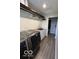 Laundry room featuring a stainless steel washer and dryer, with a sink, white cabinetry and wood look flooring at 1066 N Dogwood Way, Greenfield, IN 46140