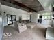 Open-concept living room featuring a beamed ceiling, a stone fireplace, access to the kitchen, and a cozy sectional sofa at 1066 N Dogwood Way, Greenfield, IN 46140