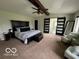 Spacious main bedroom with carpet, ceiling fan and a barn door leading to the bathroom at 1066 N Dogwood Way, Greenfield, IN 46140