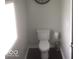 Cozy powder room featuring a classic white toilet, dark flooring, and a minimalist design at 1066 N Dogwood Way, Greenfield, IN 46140