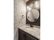 Stylish powder room with granite counters, designer wallpaper, and modern vanity lighting at 10775 Northhampton Dr, Fishers, IN 46038