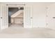 Bright, neutral bedroom featuring french doors, light carpet, and access to the staircase at 10775 Northhampton Dr, Fishers, IN 46038