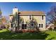 Rear exterior showcasing a spacious deck, well-maintained lawn, and light green siding at 10775 Northhampton Dr, Fishers, IN 46038