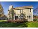 Back exterior view of home featuring a deck, lawn, and light green siding at 10775 Northhampton Dr, Fishers, IN 46038