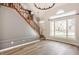 Bright living room featuring hardwood floors, large windows, and decorative chandelier at 10775 Northhampton Dr, Fishers, IN 46038