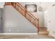 View of staircase with decorative wood banister, grey walls and light hardwood floors at 10775 Northhampton Dr, Fishers, IN 46038