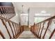 Foyer view from stairs with wood railings, a pendant light, and many windows at 10775 Northhampton Dr, Fishers, IN 46038