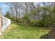 Manicured lawn in spacious backyard with partial privacy fence and mature trees at 10839 Cedar Pine Dr, Indianapolis, IN 46235