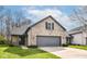 Charming brick home featuring an attached gray two-car garage and well manicured lawn at 10839 Cedar Pine Dr, Indianapolis, IN 46235