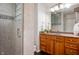 Bathroom featuring a tiled shower with glass door, with wooden cabinetry and granite countertops at 110 Washington St # 301, Indianapolis, IN 46204