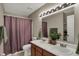 Traditional bathroom featuring a double vanity, framed mirror, and a shower with a patterned curtain at 11631 Tamarisk Blvd, Fishers, IN 46037