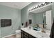 A well lit bathroom with double sinks, gray paint and a decorative plant to accentuate the space at 11631 Tamarisk Blvd, Fishers, IN 46037