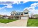 Inviting two-story brick home with blue shutters, long driveway and an attached two-car garage at 11631 Tamarisk Blvd, Fishers, IN 46037