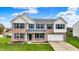 Charming two-story brick home with blue shutters, lush green lawn and attached two-car garage at 11631 Tamarisk Blvd, Fishers, IN 46037