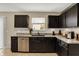Updated kitchen features granite countertops, stainless steel dishwasher, and dark wood cabinetry at 11631 Tamarisk Blvd, Fishers, IN 46037