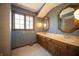 Bathroom with double sinks and vanity, framed mirrors, a window and updated fixtures at 130 Governors Ln, Zionsville, IN 46077