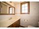 Charming half-bathroom featuring a wood-trimmed mirror, window, and a stylish sink vanity at 130 Governors Ln, Zionsville, IN 46077
