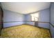 Bedroom with blue walls, green carpet, and a window at 130 Governors Ln, Zionsville, IN 46077