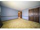 A bedroom with light-blue walls, green carpet, and natural light from a window at 130 Governors Ln, Zionsville, IN 46077
