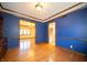 Dining room with hardwood floors and blue walls has adjacent rooms visible through entryways at 130 Governors Ln, Zionsville, IN 46077