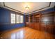 Office with hardwood floors, built-in wooden bookcases, and a large window at 130 Governors Ln, Zionsville, IN 46077