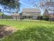 Backyard view with a pool surrounded by a black fence, green trees, and a lush lawn at 1394 Cherry Tree Rd, Avon, IN 46123