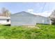 Backyard features grassy area with a block wall structure and house with siding at 1414 Waldemere Ave, Indianapolis, IN 46241