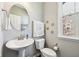 Half bathroom featuring a pedestal sink, round mirror, and beach decor at 14413 Arnett Dr, Carmel, IN 46033