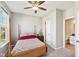 Cozy bedroom featuring a wooden bed frame, neutral walls, a ceiling fan, and an attached bathroom at 14413 Arnett Dr, Carmel, IN 46033
