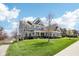 Charming two-story home with manicured lawn, complemented by a walkway and mature trees at 14413 Arnett Dr, Carmel, IN 46033
