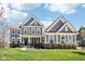 Inviting two-story home with a covered front porch, manicured lawn and beautiful architectural details at 14413 Arnett Dr, Carmel, IN 46033