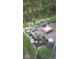 Tranquil outdoor patio with lush greenery, stone accents and a cozy fire pit at 14413 Arnett Dr, Carmel, IN 46033
