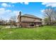 Spacious backyard featuring a large lawn, wooden deck, and a black metal fence at 1444 Trail Creek Ct, Carmel, IN 46032