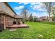 Expansive backyard with a wooden deck, lush lawn, and black metal fencing at 1444 Trail Creek Ct, Carmel, IN 46032