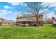 Expansive backyard with mature trees, green lawn, and wooden deck, perfect for outdoor activities at 1444 Trail Creek Ct, Carmel, IN 46032