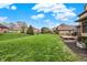 Lush green backyard with a well-maintained lawn, bordered by a black fence and mature trees at 1444 Trail Creek Ct, Carmel, IN 46032