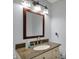 Elegant bathroom vanity with granite countertops, a framed mirror, and modern lighting fixtures at 1444 Trail Creek Ct, Carmel, IN 46032