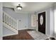 Bright foyer featuring hardwood floors, decorative rug, staircase and a dark wood door flanked by windows at 1444 Trail Creek Ct, Carmel, IN 46032
