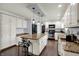 Bright kitchen featuring white cabinets, granite countertops, an island with seating, and wood flooring at 1444 Trail Creek Ct, Carmel, IN 46032